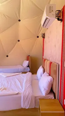 a room with three beds in a tent at LAVRA lUXURY CAMP in Wadi Rum
