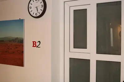 a clock on a wall next to a door at PetraEcho lodge Section B Home in Wadi Musa