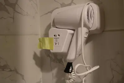 a blow dryer hanging on a wall in a bathroom at PetraEcho lodge Section B Home in Wadi Musa