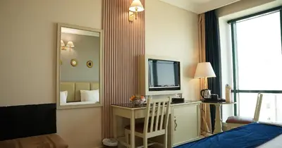 a room with a bed and a tv and a mirror at Amman West Luxury Hotel By Azar in Amman
