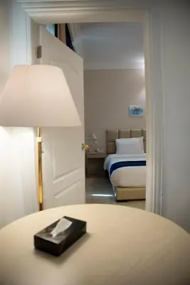 a bedroom with a bed and a table with a lamp at Amman West Luxury Hotel By Azar in Amman