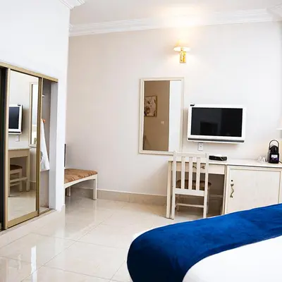 a bedroom with a bed and a desk with a tv at Amman West Luxury Hotel By Azar in Amman