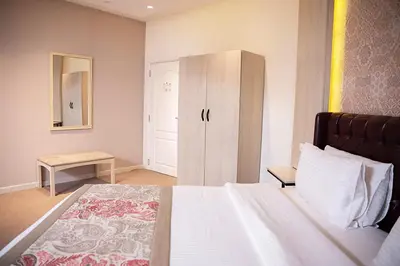 a bedroom with a large bed and a cabinet at Amman West Luxury Hotel By Azar in Amman
