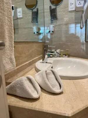 a bathroom sink with two towels on a counter at Amman West Luxury Hotel By Azar in Amman