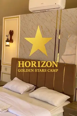 a star above a bed with a houston golden stars camp sign at Horizon Star Golden Camp in Wadi Rum