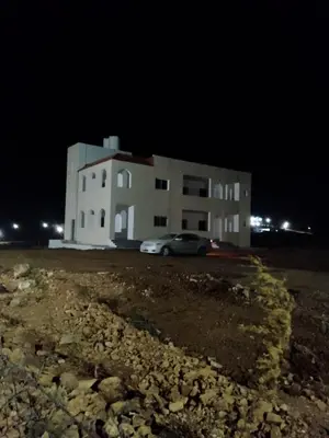 a building with a car parked in front of it at night at The Fog mountain in Kerak
