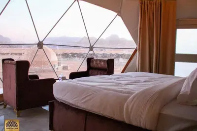 a bedroom with a bed and a large window at Wadi Rum in Al Jafr