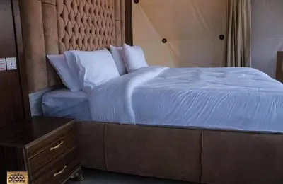 a bedroom with a blue bed with a wooden headboard at Wadi Rum in Al Jafr