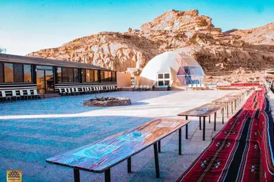 a group of benches in front of a tent at Wadi Rum in Al Jafr