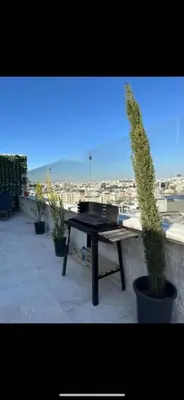 a potted plant sitting next to a table on a balcony at Doctor roof in Amman