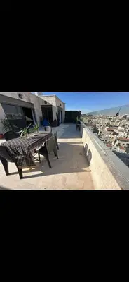 a table and benches on the side of a building at Doctor roof in Amman