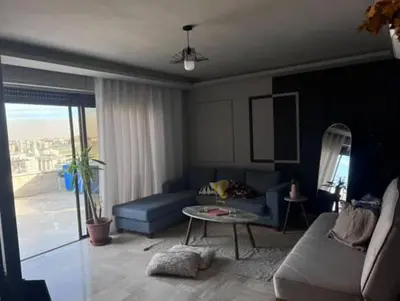 a living room with a blue couch and a table at Doctor roof in Amman