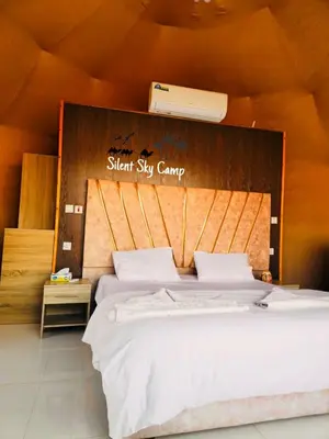a bedroom with a large bed with a silent sky camp sign at SILENT SKY lUXURY CAMP in Wadi Rum