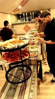 a group of people standing around a long table with food at SILENT SKY lUXURY CAMP in Wadi Rum