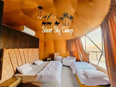 two beds in a room with a sign that reads silent six camp at SILENT SKY lUXURY CAMP in Wadi Rum