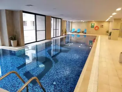 a pool with a blue floor in a building at Studio at Damac Jordan in Amman