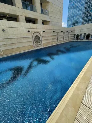 a pool of blue water in front of a building at Studio at Damac Jordan in Amman