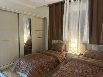 a bedroom with two beds and a mirror at A double bed apartment in heart of Amman شارع سلطان الهند خلف ش عبدالله غوشه in Amman