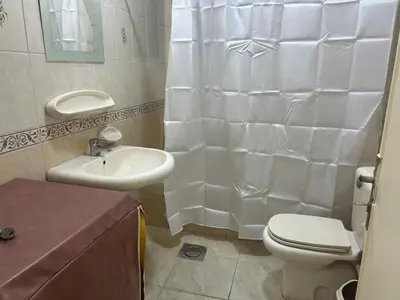 a white bathroom with a toilet and a sink at A double bed apartment in heart of Amman شارع سلطان الهند خلف ش عبدالله غوشه in Amman