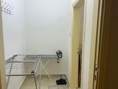 a metal bed in a room with a table at A double bed apartment in heart of Amman شارع سلطان الهند خلف ش عبدالله غوشه in Amman