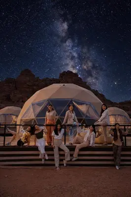 a group of people standing in front of a tent at RUM AlLIRA lUXURY CAMP in Wadi Rum