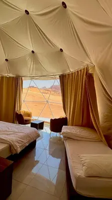 a bedroom with two beds and a view of the desert at RUM AlLIRA lUXURY CAMP in Wadi Rum