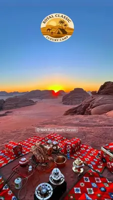 a picnic in the desert with the sun setting at RUM ROYAL CLASSIC lUXURY CAMP in Disah
