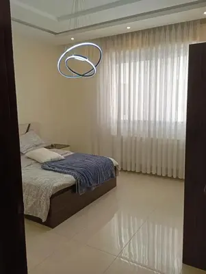 a bedroom with a bed and a chandelier at شقه مفروشه in Amman
