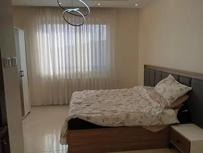 a bedroom with a bed and a chandelier at شقه مفروشه in Amman
