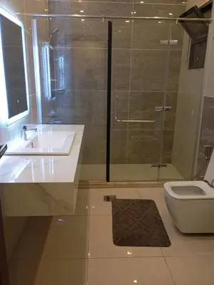 a bathroom with a shower and a sink and a toilet at شقه مفروشه in Amman