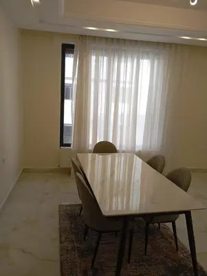 a dining room with a table and chairs and a window at شقه مفروشه in Amman