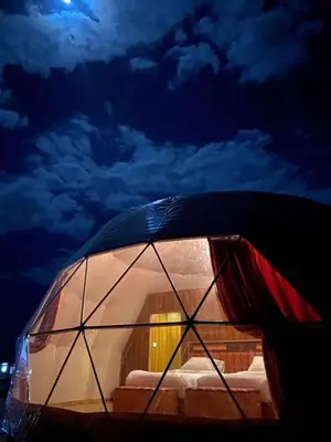 a dome tent with a bed in the sky at moon and sky camp in Wadi Rum