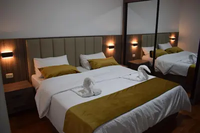 two beds in a hotel room with towels on them at Al-Farouq Suites in Amman