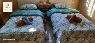 two beds sitting next to each other in a room at استراحة الباشا albash farm stay in Al Karāmah
