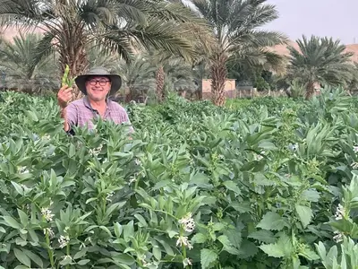 a man wearing a hat standing in a field at استراحة الباشا albash farm stay in Al Karāmah