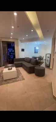 a living room with a couch and a table at DAMAC Tower Amman boulevard برج داماك - عمان البوليفارد العبدلي in Amman