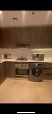 a kitchen with a stove and a washing machine at DAMAC Tower Amman boulevard برج داماك - عمان البوليفارد العبدلي in Amman