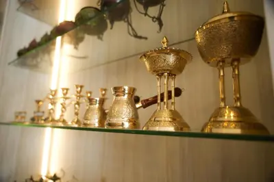 a shelf with gold items on it with candles at Corner View Hotel in Wadi Musa