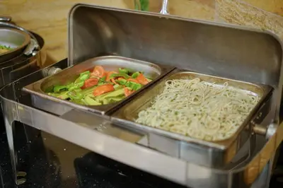a tray of noodles and vegetables in an oven at Corner View Hotel in Wadi Musa
