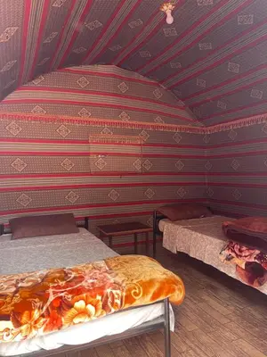 a room with two beds and a striped wall at Wadi Rum Bedouin Life in Wadi Rum
