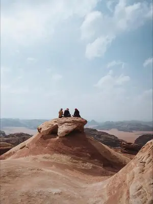 three people sitting on top of a rock at Wadi Rum Bedouin Life in Wadi Rum