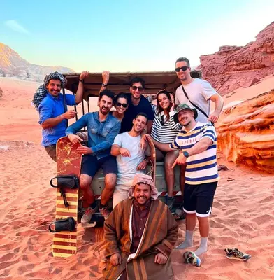 a group of people posing for a picture in the desert at Wadi Rum Bedouin Life in Wadi Rum