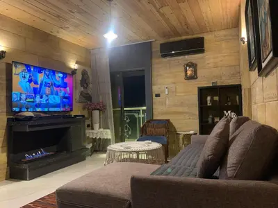 a living room with a couch and a flat screen tv at Aqaren Apartment in Amman