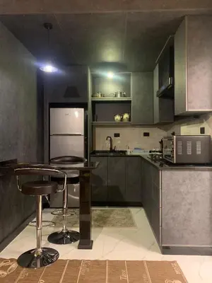 a kitchen with a counter and a bar in it at Aqaren Apartment in Amman