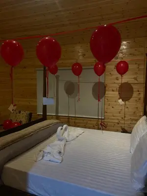 a bed in a room with red balloons at Cherry farm in Ajloun