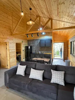 a living room with a couch and a kitchen at Cherry farm in Ajloun
