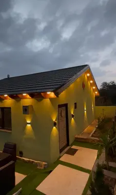 a white house with a door and lights on it at Cherry farm in Ajloun