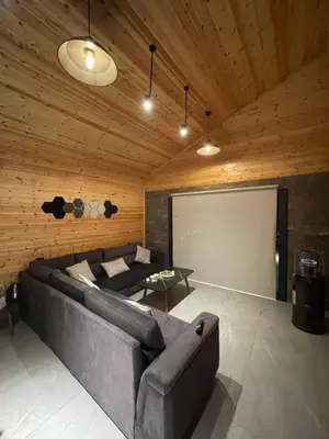 a living room with a couch and a projection screen at Cherry farm in Ajloun