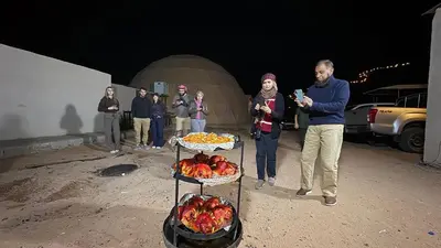 a group of people standing around a display of fruit at SARH lUXURY CAMP in Wadi Rum