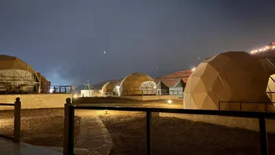 a group of domes in a field at night at SARH lUXURY CAMP in Wadi Rum